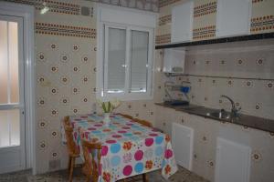 a small kitchen with a table and a sink at As Carreiras in Bueu