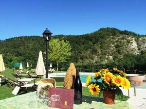 un tavolo con fiori e una bottiglia di vino di Relais Valguerriera ad Apecchio