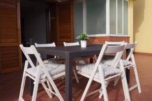 a black table and chairs with a potted plant on it at La Casa de Maia in Belpasso