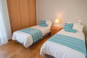 - 2 lits jumeaux dans une chambre avec une lampe sur une table dans l'établissement Alto da Ria 37, à Alvor