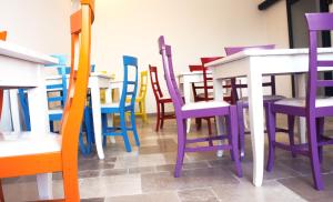 a group of colorful chairs and tables in a room at B&B Margherita in Ostuni