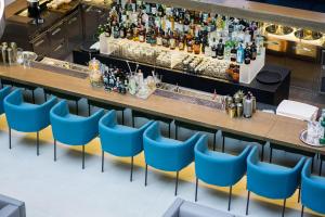 a bar with blue chairs in a restaurant at Posia Retreat & Spa UNA Esperienze in San Foca