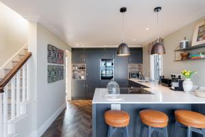 a kitchen with a island with stools and a counter top at Beam Ends - Beachfront House, Parking, Allows Pet in Beesands +32 photos