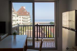 a kitchen with a view of a balcony at Studio moderne accès plage, piscine et tennis in Cabourg