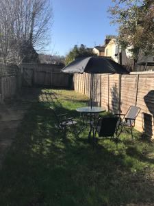 a table and chairs under an umbrella in a yard at Cedar Villa - Perfect For Longer Stays in Chatham