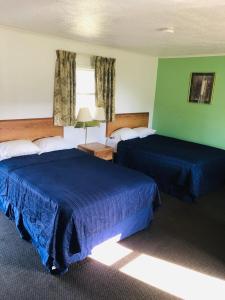 A bed or beds in a room at Woodridge Motel