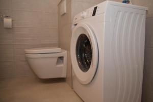 a white washing machine in a bathroom with a toilet at Apartment DOLEA in Split +47 photos
