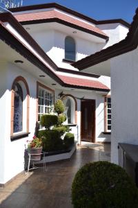 uma casa branca com um pátio com flores e plantas em La Aurora Hotel Like Home em Huamantla