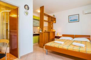 a small bedroom with a bed and a kitchen at Apartments Gracia - with great view in Rabac