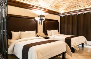 Habitación de hotel con 2 camas y lámpara de araña. en Imperio De Angeles, en San Miguel de Allende