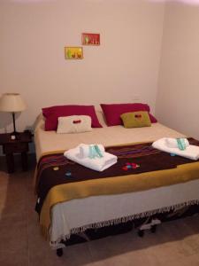a bedroom with a large bed with towels on it at Los Agustinos in Purmamarca