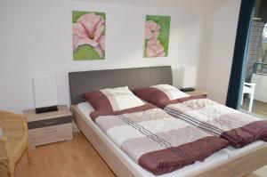 1 cama en una habitación con 2 cuadros en la pared en Ferienhäuser Rhön - Haus Natalie & Haus Helene, en Hausen