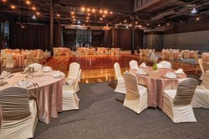 une salle de banquet avec des tables blanches et des chaises blanches dans l'établissement Bally's Vicksburg, à Vicksburg
