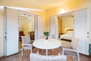 a dining room with a table and chairs and a bed at Romanos Beach Villas in Romanu
