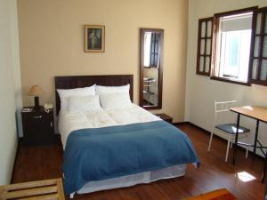 sypialnia z dużym łóżkiem i niebieskim kocem w obiekcie La Posada Del Fraile w mieście Arequipa