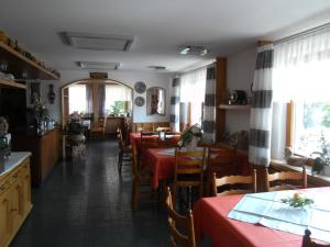 a restaurant with tables and chairs with red table cloth at Grubstuben in Schonach