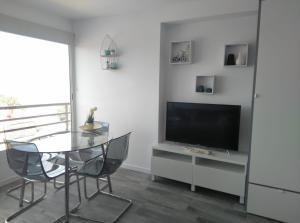 een eetkamer met een glazen tafel en een televisie bij BSB Surf&Beach Apartment Salou in Salou