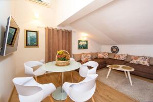 a living room with a couch and a table and chairs at Apartments Villa Jovovic in Budva