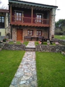 uma casa de pedra com uma varanda em cima em La Bolerina em Celorio