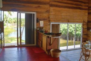 una cocina con paredes de madera y una gran puerta corredera de cristal en Natura luxury lodge, en Ouidah