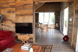 a living room with a red couch and a television at Natura luxury lodge in Ouidah