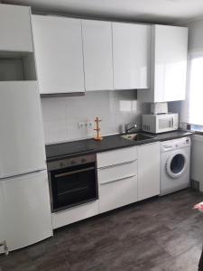 a kitchen with white cabinets and a sink and a dishwasher at Apartamento en Casco Histórico a 300 metros de la playa in Castro-Urdiales