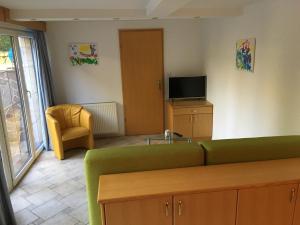 een woonkamer met een groene bank en een televisie bij J-Max in Bled