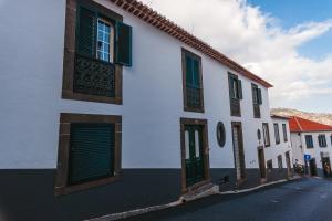 フンシャルにあるFortaleza do Pico Apartmentの緑の襖のある白い建物