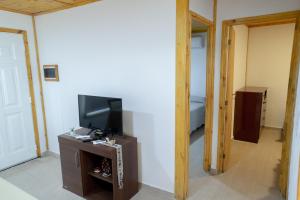 Habitación con TV y dormitorio. en Cabañas Las Achiras en Sierra de la Ventana