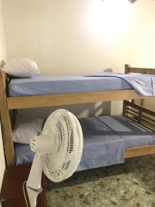 naast 2 stapelbedden staat een ventilator bij Playa Samara Hostel in Camarones