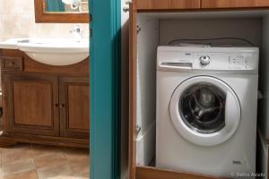 a bathroom with a washing machine and a sink at Aegean Panorama Apartments in Akhladherí