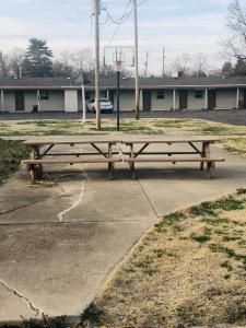 a wooden picnic table sitting in a parking lot at Woodridge Motel in Terre Haute