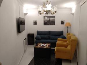 sala de estar con sofá azul y silla en Alojamiento Rural Carmen, en Setenil