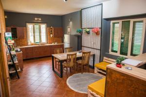 a kitchen and dining room with a table and chairs at Our Way Guest House & Hostel in Shkodër