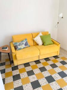a yellow couch with pillows on it in a living room at La casetta di nonno Vittorio in Albissola Marina +34 photos