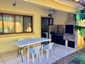 a table and chairs on the patio of a house at Paúba · Paúba Beach House -Em lindo condomínio c/ piscina in São Sebastião