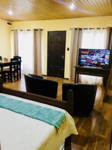a bedroom with a bed and a table and a piano at Hospedaje “ El Segoviano “ in Carmelo