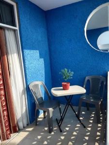 tavolo e sedie in una stanza con parete blu di Casa de Huéspedes May a Ixtapan de la Sal