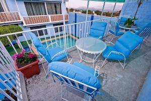 a balcony with blue chairs and a table and a pool at Casa de Huéspedes May in Ixtapan de la Sal
