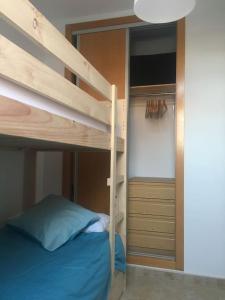 Un dormitorio con una litera con escalera y un armario. en Apartamento Ahola, en Archena