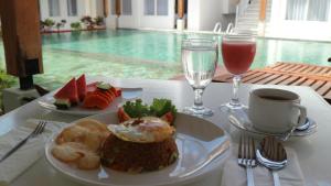 a table with a plate of food and a drink at Sinom Borobudur Heritage Hotel in Borobudur