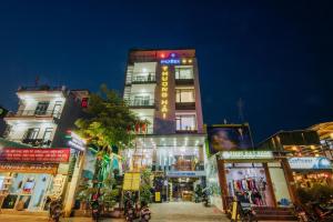 um edifício alto com sinais de néon numa cidade em Thuong Hai Hotel em Phong Nha