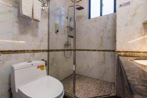 a bathroom with a shower and a toilet and a sink at Hainan Jingshan Hotel in Haikou