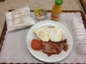 a white plate topped with eggs, sausage and bacon at Bororen Motel in Bororen