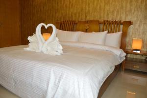 Yara Suites في بريدة: ديكور بجعة على سرير في غرفة الفندق
