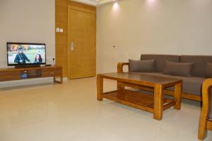 a living room with a couch and a table and a tv at Yara Suites in Buraydah