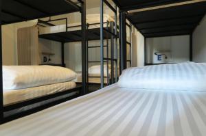 two bunk beds are in a room withthritisthritisthritisthritisthritisthritisthritisthritis at Phuket Marine Poshtel - SHA Plus in Chalong 