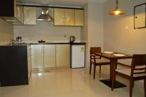 a kitchen with a table and a white refrigerator at Yara Suites in Buraydah