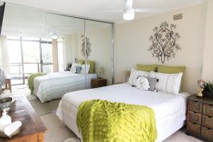 - une chambre avec 2 lits et un miroir dans l'établissement Beauty at the Beach - modern beachfront apartment, à Port Macquarie
