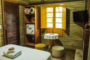 a room with a table and two stools and a window at Pousada & Camping Nativos dos Canyons in Praia Grande